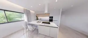 Modern white kitchen with marble island pendant hood and built in oven large window and light wood floors create an airy space